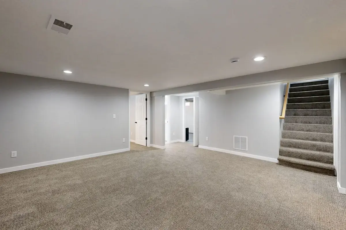 Example after: dry finished basement with new carpet and stairs
