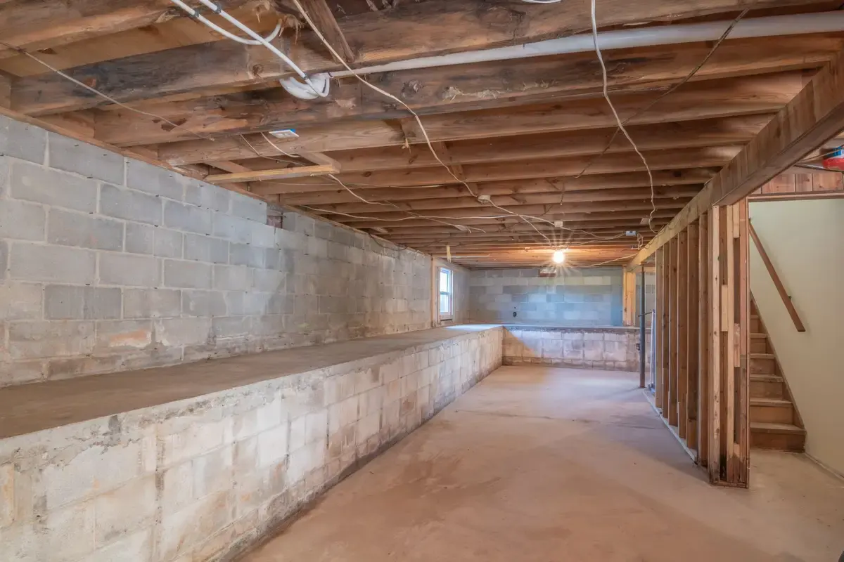 Example before: basement stripped to block walls and exposed joists